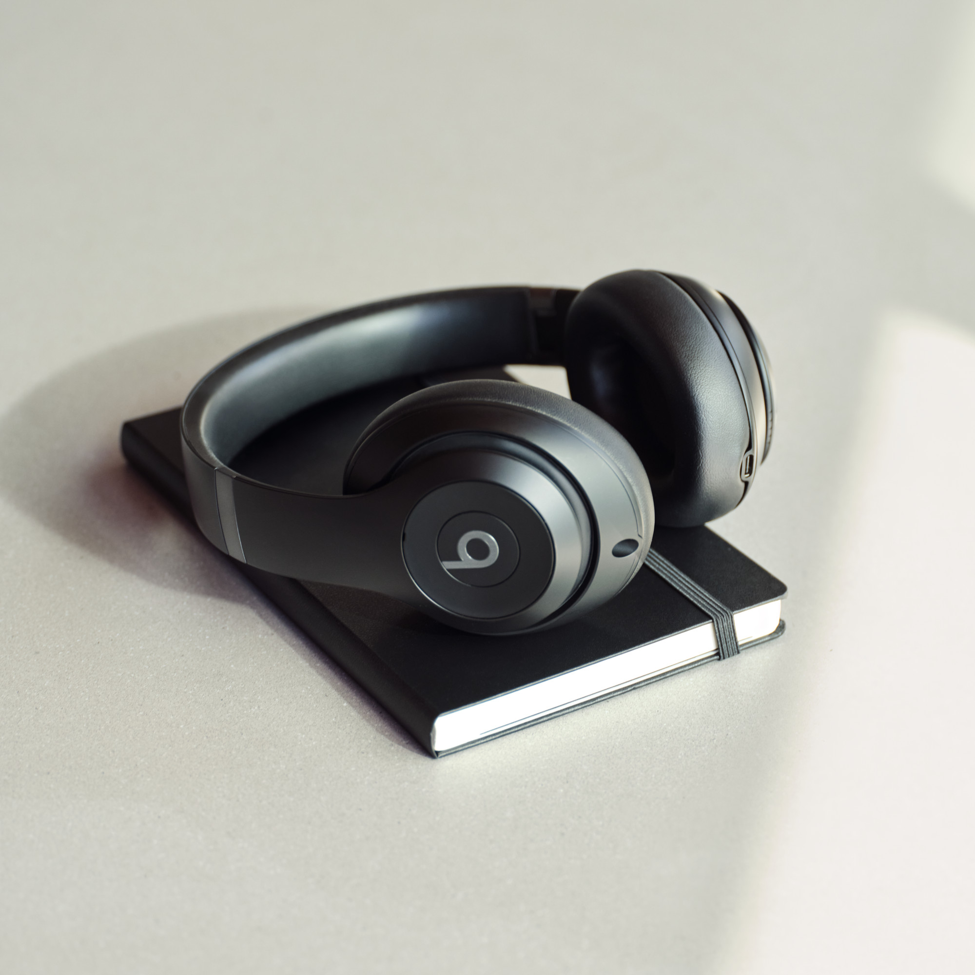 ノートの上に置いたブラック本体。USB-C端子が見える。ノートは別(画像:Beats/Apple)